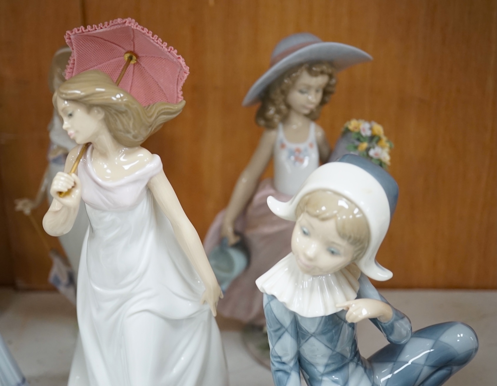 A group of Lladro figures to include ‘Lamplighter’ and ‘All aboard’, largest 48cm high. Condition - good